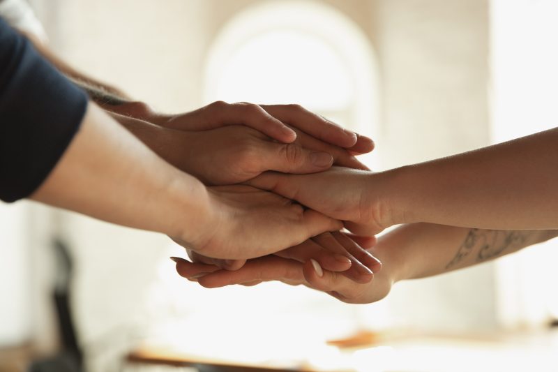 Close up of caucasian male and female hands, covering one another, shaking. Concept of business, finance, job. Copyspace for ad. Education, communication and freelance. Teambuilding, support.